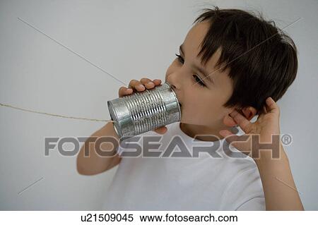 Boy using a tin can as a phone. View Large Photo Image Stock Photography - Boy using a tin can as a phone.. Fotosearch