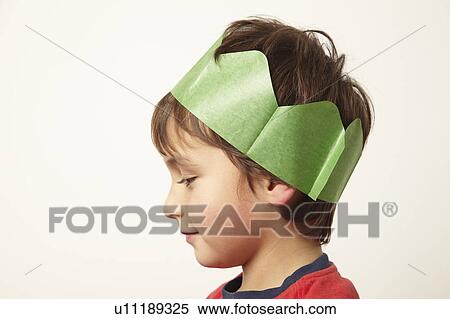 Stock Photography - Boy wearing paper crown hat at Christmas. Fotosearch