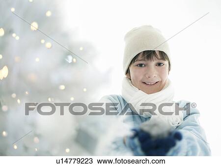 Boy with present by lit Xmas tree View Large Photo Image Stock Image - Boy with present by lit Xmas tree. Fotosearch