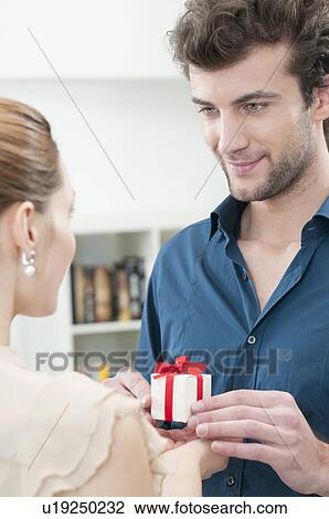 Stock Image - Boyfriend give a gift to his girlfriend. Fotosearch