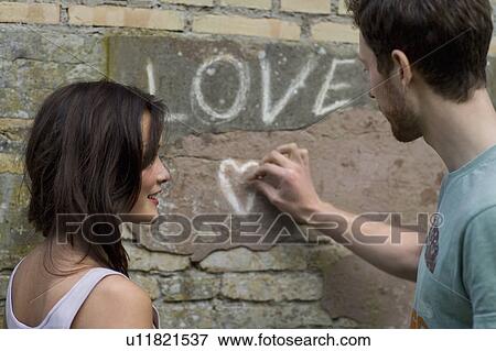 Boyfriend writing LOVE on a wall View Large Photo Image Stock Photo - Boyfriend writing LOVE on a wall. Fotosearch