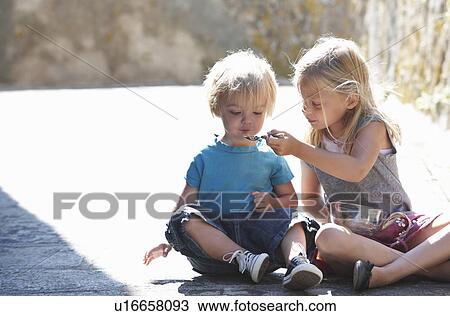 Brother and sister having a snack View Large Photo Image Stock Image - Brother and sister having a snack. Fotosearch