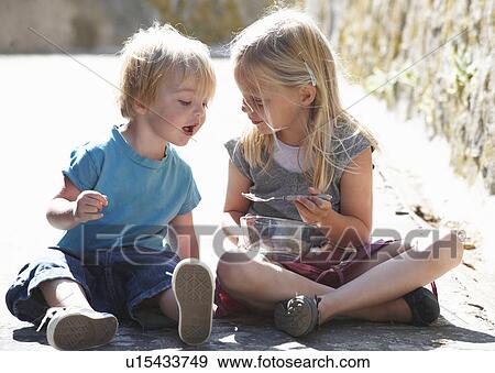 Brother and sister having a snack View Large Photo Image Stock Photo - Brother and sister having a snack. Fotosearch