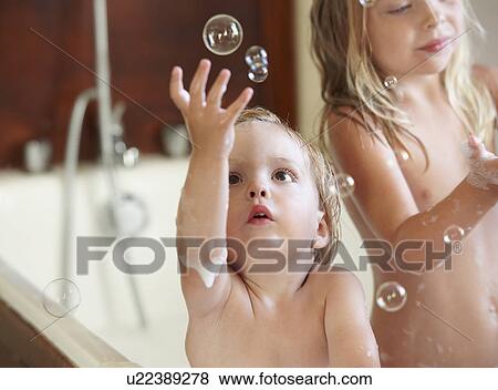 Stock Photo - Brother and sister in bath, bubbles. Fotosearch