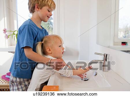 Stock Photograph - Brother and sister washing their hands. Fotosearch