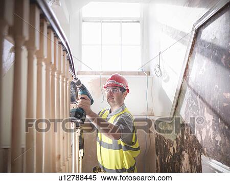 Stock Photography - Builder renovating staircase. Fotosearch