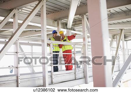 Builder showing architect constructions View Large Photo Image Stock Image - Builder showing architect constructions. Fotosearch