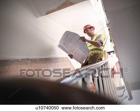 Builder with plans on staircase View Large Photo Image Stock Image - Builder with plans on staircase. Fotosearch