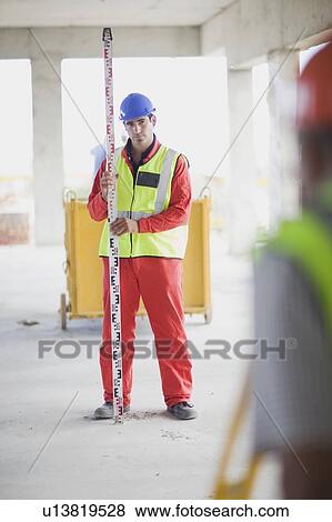 Stock Photo - Building worker doing some measuring. Fotosearch