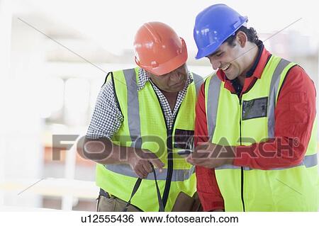 Building workers writing an sms View Large Photo Image Stock Photograph - Building workers writing an sms. Fotosearch