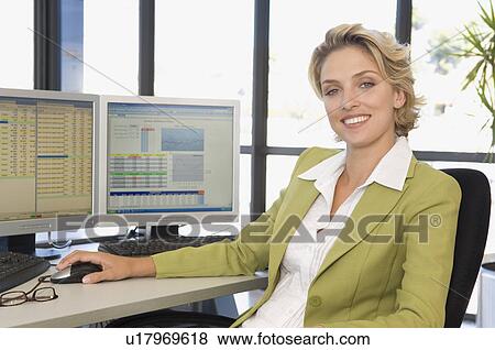 Stock Photo - Buisness woman at the computer smiling. Fotosearch