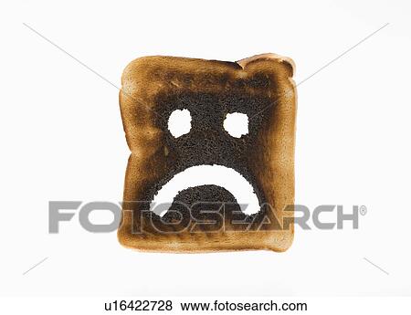 Stock Photo - Burnt toast with sad face on it. Fotosearch
