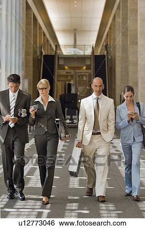 Stock Photograph - Business people walking down a corridor. Fotosearch