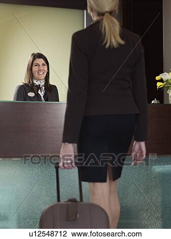 Business woman aproaching porter at hotel front desk View Large Photo Image Stock Image - Business woman aproaching porter at hotel front desk. Fotosearch