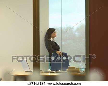 Business woman at window View Large Photo Image Picture - Business woman at window. Fotosearch