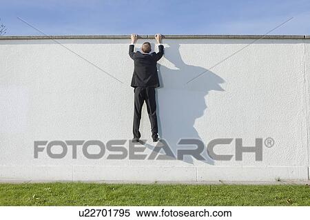 Businessman climbing over wall View Large Photo Image Stock Photography - Businessman climbing over wall. Fotosearch
