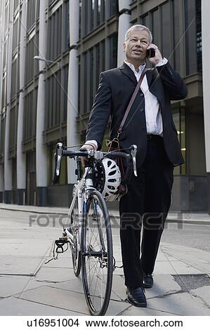 Businessman pushing bicycle View Large Photo Image Picture - Businessman pushing bicycle. Fotosearch