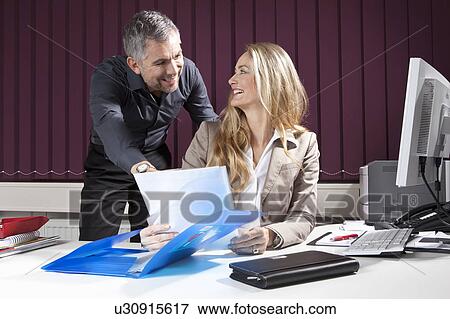 Stock Photo - Businesspeople at desk with documents. Fotosearch