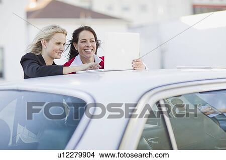 Picture - Businesspeople looking at laptop. Fotosearch