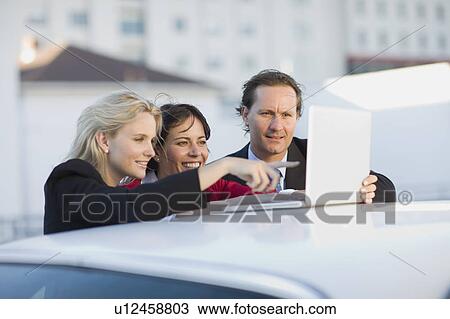 Stock Image - Businesspeople looking at laptop. Fotosearch