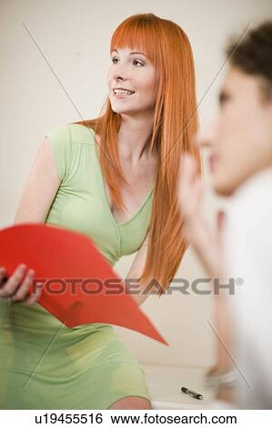 Stock Photograph - Businesswoman holding folder in office. Fotosearch
