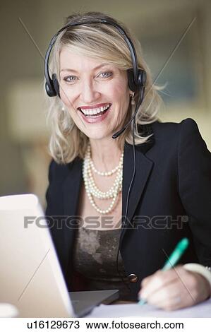 Businesswoman in headset using laptop View Large Photo Image Stock Image - Businesswoman in headset using laptop. Fotosearch