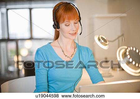 Businesswoman in headset using laptop View Large Photo Image Stock Photo - Businesswoman in headset using laptop. Fotosearch