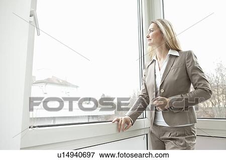 Businesswoman looking out window View Large Photo Image Stock Photo - Businesswoman looking out window. Fotosearch