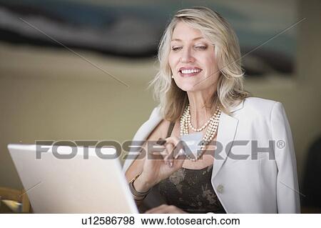 Stock Photo - Businesswoman shopping on the internet. Fotosearch