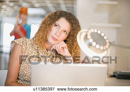 Stock Photo - Businesswoman thinking and using laptop. Fotosearch
