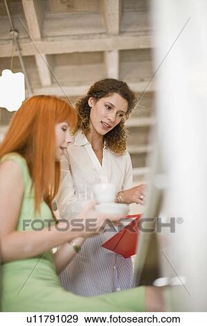 Stock Photo - Businesswomen working together in office. Fotosearch