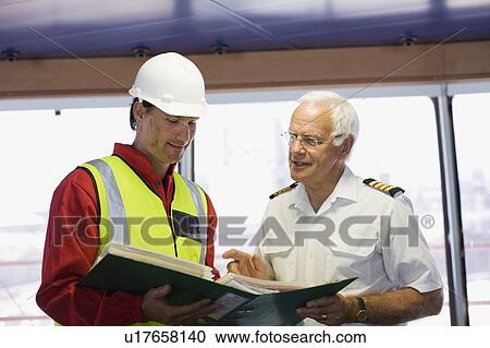 Captain of a ship discussing with a work View Large Photo Image Stock Image - Captain of a ship discussing with a work. Fotosearch