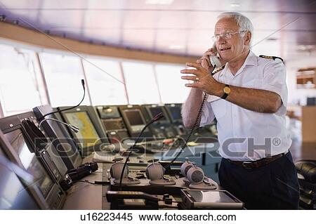 Captain of a ship having a phone call View Large Photo Image Stock Photography - Captain of a ship having a phone call. Fotosearch