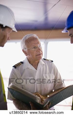 Captain of a ship talking to workers View Large Photo Image Picture - Captain of a ship talking to workers. Fotosearch