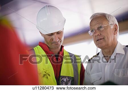 Captain of a ship talking to workers View Large Photo Image Stock Image - Captain of a ship talking to workers. Fotosearch