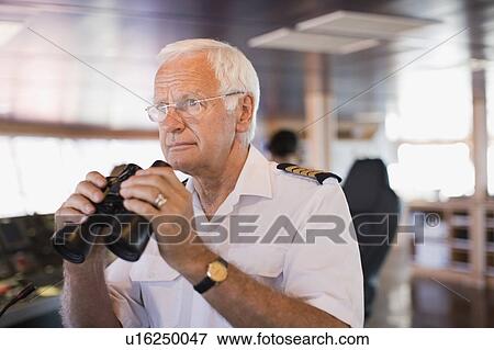 Stock Photo - Captain on ship holding a telescope. Fotosearch