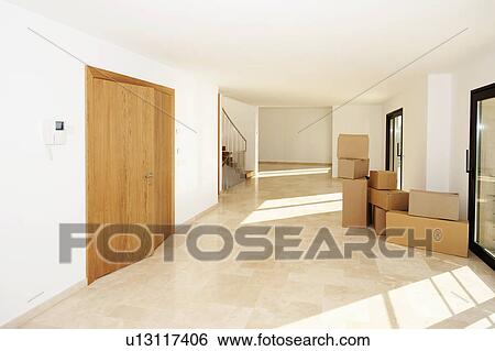 Stock Photograph - Cardboard boxes in modern living room. Fotosearch