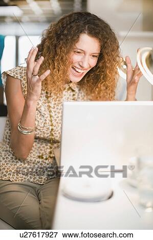 Stock Photo - Cheering businesswoman using laptop. Fotosearch