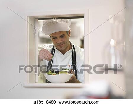 Stock Image - Chef preparing food in restaurant. Fotosearch
