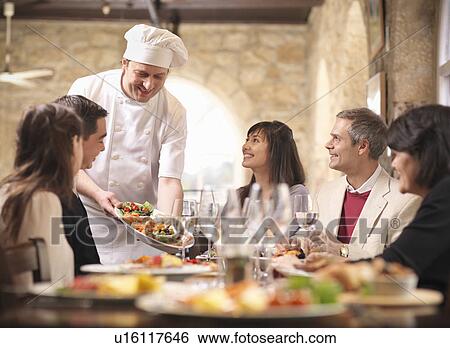 Chef serving people in restaurant View Large Photo Image Stock Photograph - Chef serving people in restaurant. Fotosearch