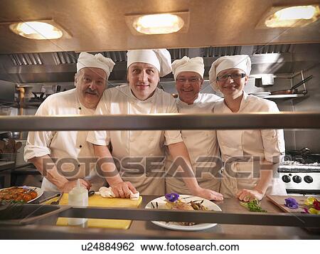Stock Image - Chefs smiling in kitchen. Fotosearch