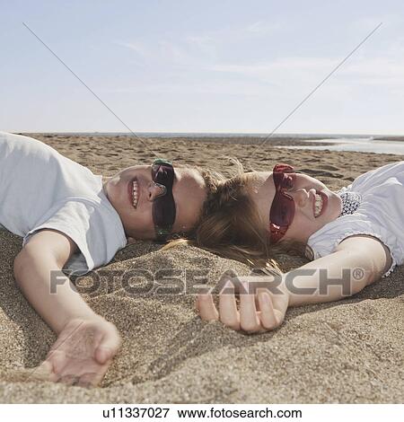 Children with sunglasses laying on sand View Large Photo Image Stock Photo - Children with sunglasses laying on sand. Fotosearch
