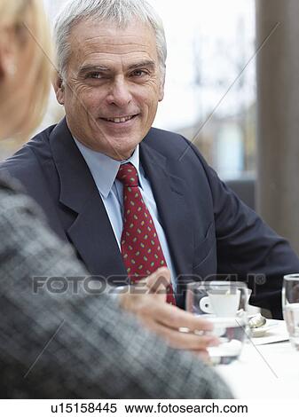Stock Photography - Close up of elderly man in a group meeting. Fotosearch