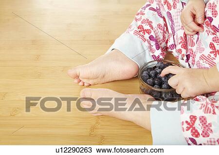 Stock Image - Close up of girl with blueberries. Fotosearch