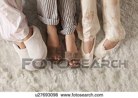 Stock Photo - Close-up of three females in slippers. Fotosearch