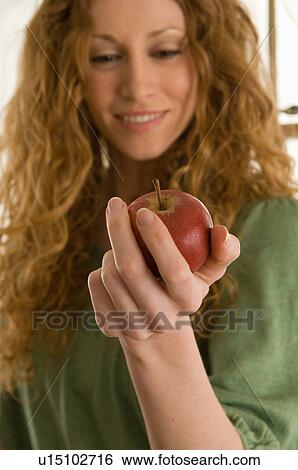 Close up of woman holding apple View Large Photo Image Stock Photograph - Close up of woman holding apple. Fotosearch