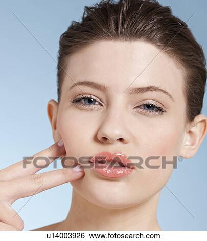 Close up of woman touching her cheeks View Large Photo Image Stock Photograph - Close up of woman touching her cheeks. Fotosearch