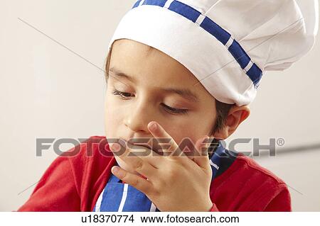 Picture - Close up of young boy licking fingers. Fotosearch