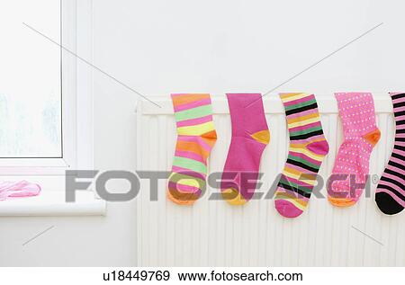 Stock Photo - colored socks drying on radiator. Fotosearch