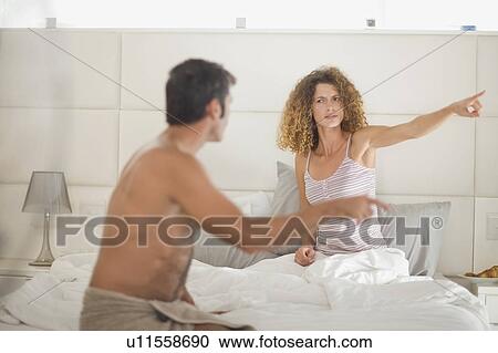 Stock Image - Couple arguing in bedroom. Fotosearch